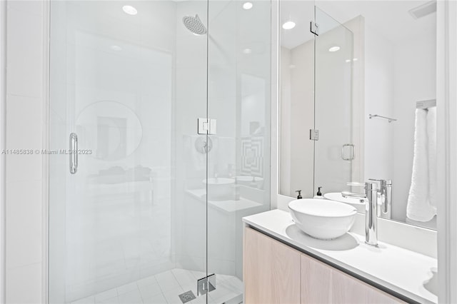 bathroom featuring a shower with door, large vanity, and double sink