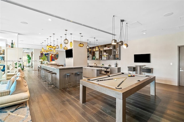 rec room with bar, pool table, and dark hardwood / wood-style flooring