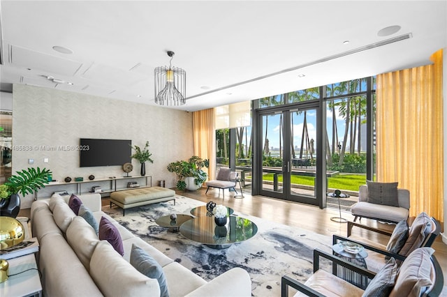 living room with an inviting chandelier, floor to ceiling windows, and hardwood / wood-style flooring