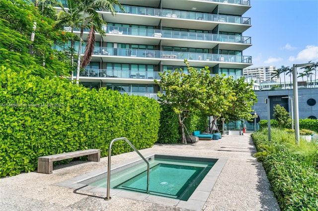 view of swimming pool with a hot tub