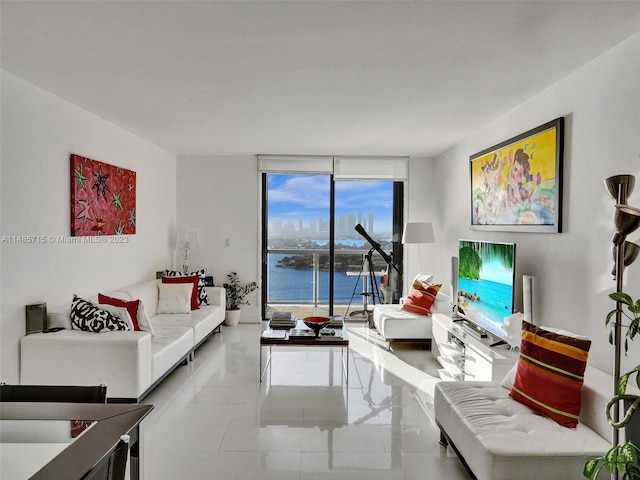 living room with a water view, tile patterned flooring, and floor to ceiling windows