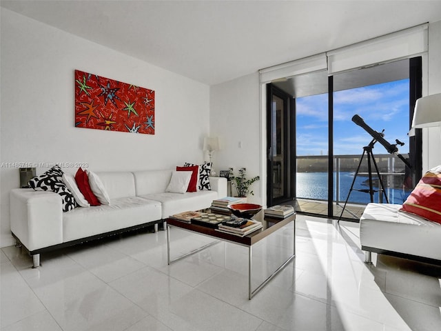 living room with a wall of windows, a water view, and tile patterned flooring