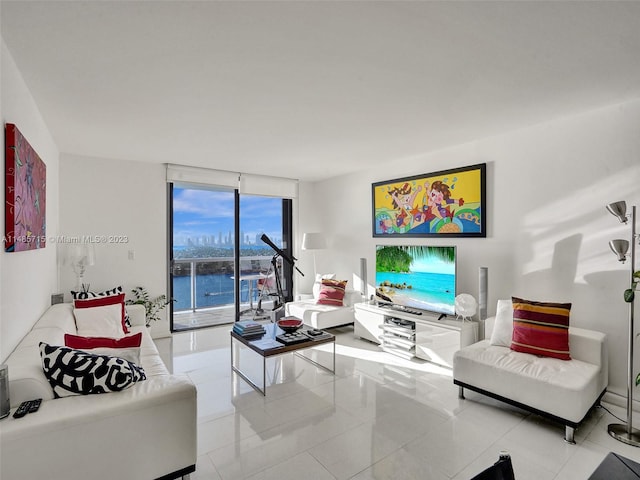 living room with a water view, a wall of windows, and light tile patterned floors