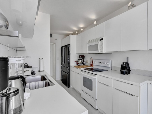 kitchen featuring white cabinets, white appliances, and light tile patterned floors