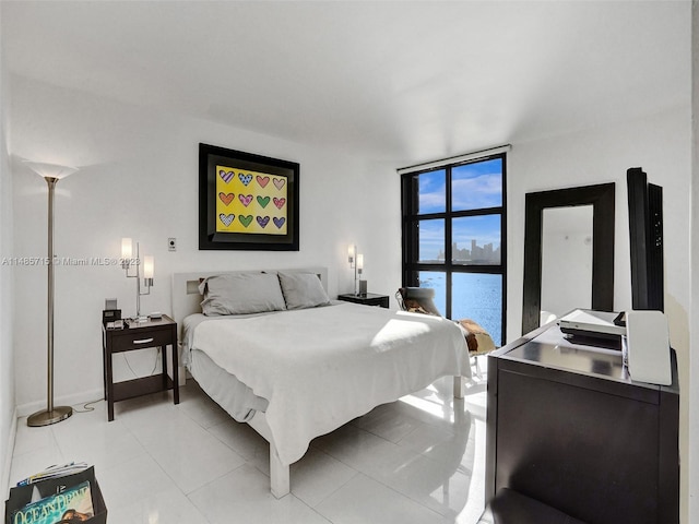 bedroom with a wall of windows and light tile patterned floors