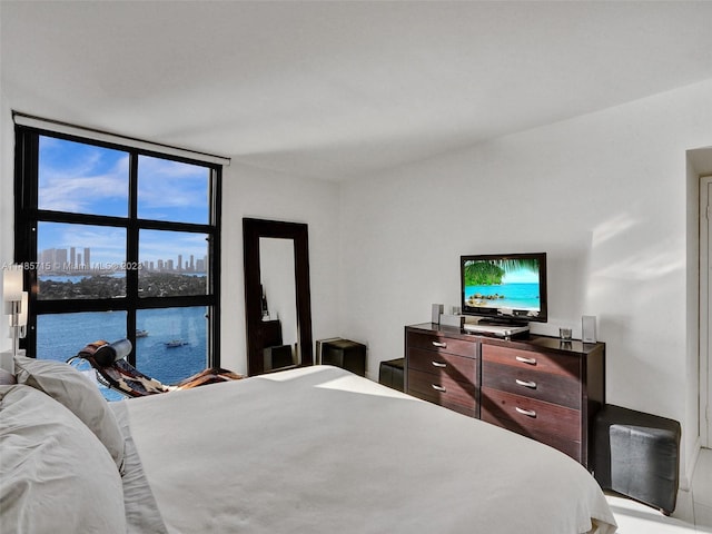 bedroom with a wall of windows and a water view