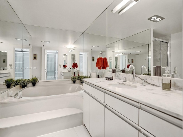 bathroom featuring tile patterned flooring, a bathing tub, and vanity