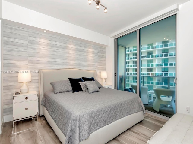 bedroom featuring light wood-type flooring and expansive windows