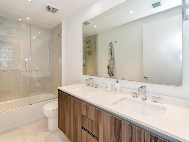 full bathroom featuring shower / bath combination with glass door, vanity, and toilet