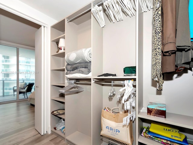 walk in closet with light hardwood / wood-style floors