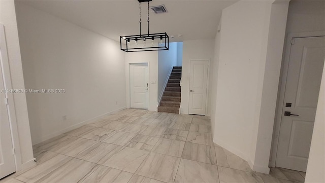 hallway featuring light tile floors and an inviting chandelier