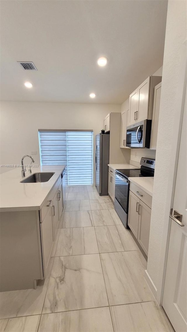 kitchen with light tile flooring, white cabinets, appliances with stainless steel finishes, and sink