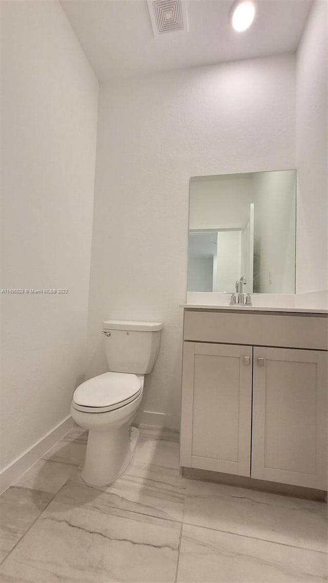 bathroom featuring toilet, tile floors, and vanity with extensive cabinet space