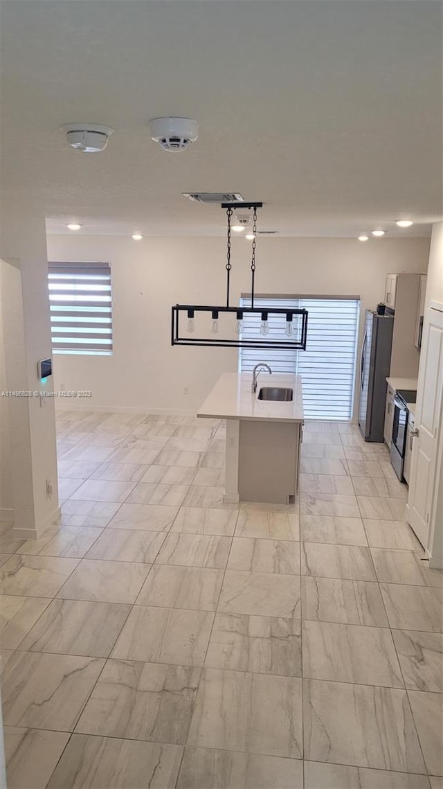 kitchen featuring light tile floors, white cabinetry, and sink