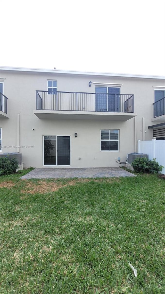 back of property with a yard, a patio area, and central AC