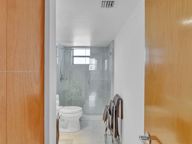 bathroom featuring walk in shower, toilet, and tile patterned flooring