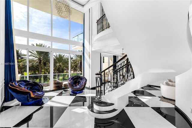 staircase with light tile floors, a high ceiling, and an inviting chandelier