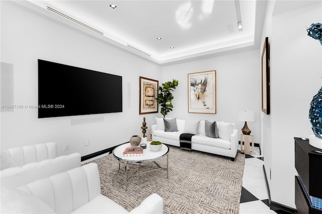 living room featuring light tile floors and a tray ceiling