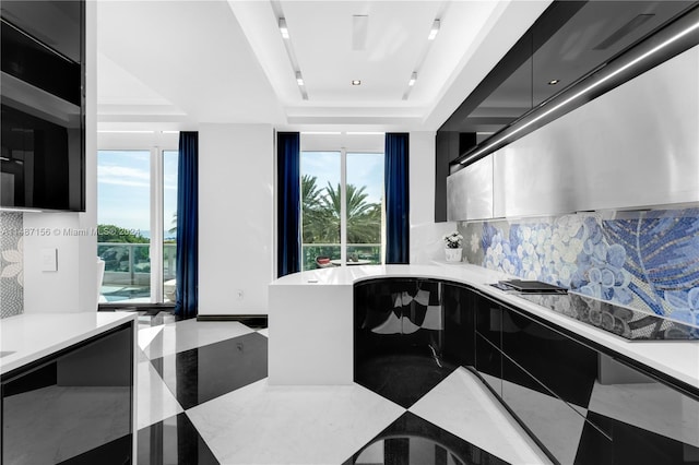 kitchen with a tray ceiling and tasteful backsplash