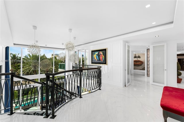 corridor featuring an inviting chandelier and light tile flooring