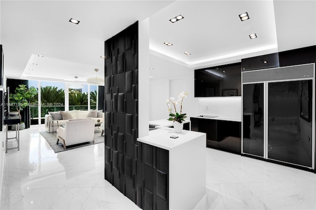 kitchen featuring light tile floors, decorative light fixtures, and a tray ceiling