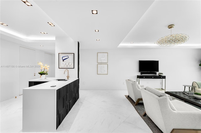 tiled living room with a raised ceiling and sink