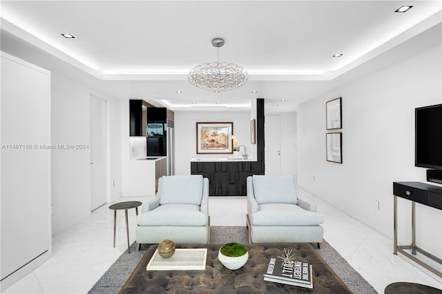 tiled living room with a raised ceiling, a notable chandelier, and sink