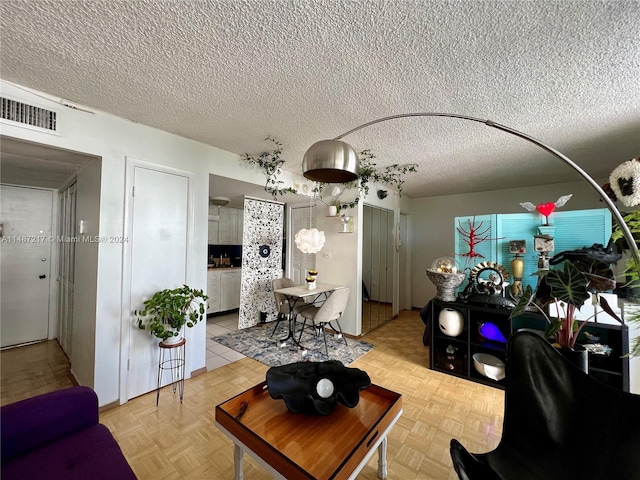 living room with light parquet floors and a textured ceiling