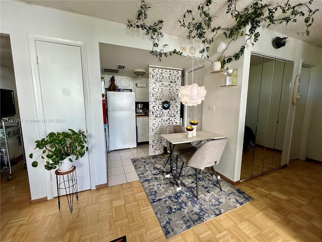 tiled dining area with a textured ceiling