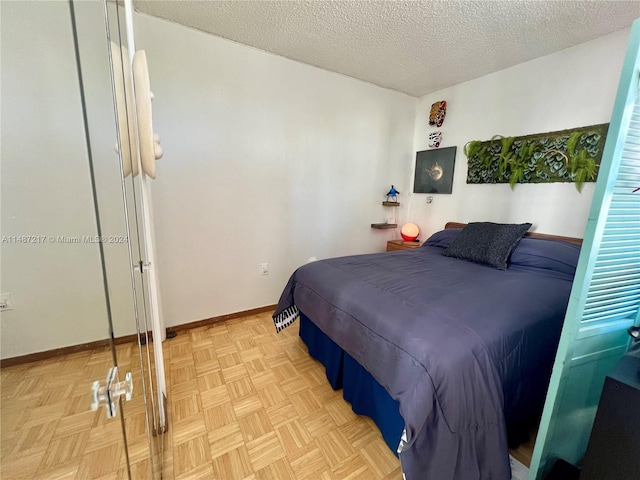 bedroom featuring a textured ceiling and light parquet flooring