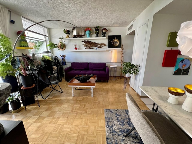 living room featuring a textured ceiling and light parquet flooring