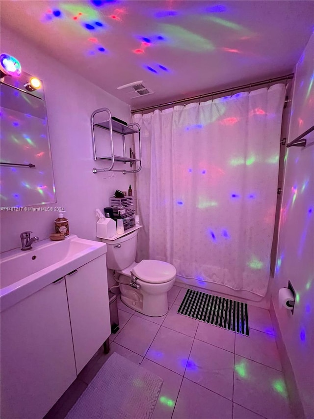 bathroom featuring tile flooring, vanity, and toilet