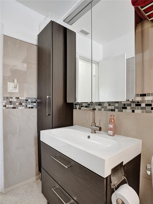 bathroom with backsplash, large vanity, toilet, and tile walls