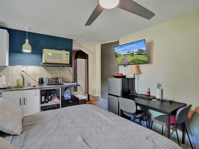 bedroom featuring stainless steel fridge, ceiling fan, and sink