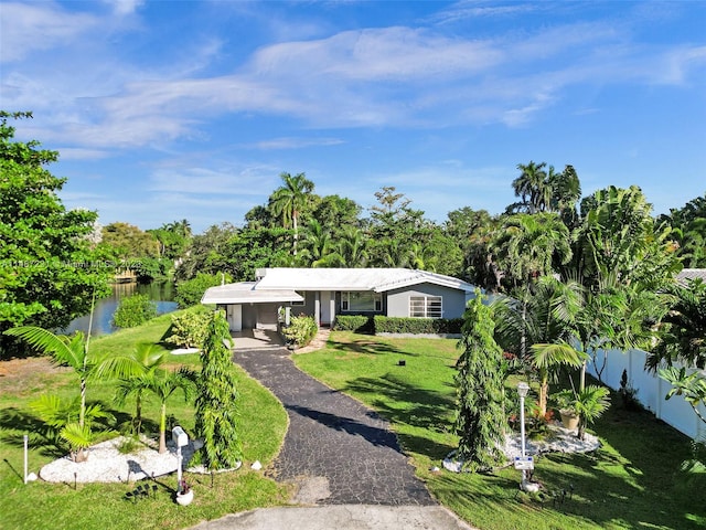 ranch-style home featuring a water view and a front lawn