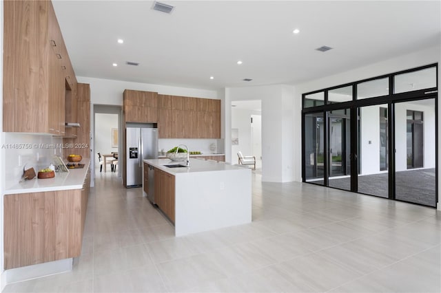 10455 SW 57th Ct, Cooper City, FL 33328 - kitchen featuring light tile flooring, stainless steel fridge with ice dispenser, a kitchen island with sink, and sink