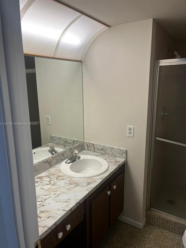 bathroom with vanity, tile flooring, and walk in shower