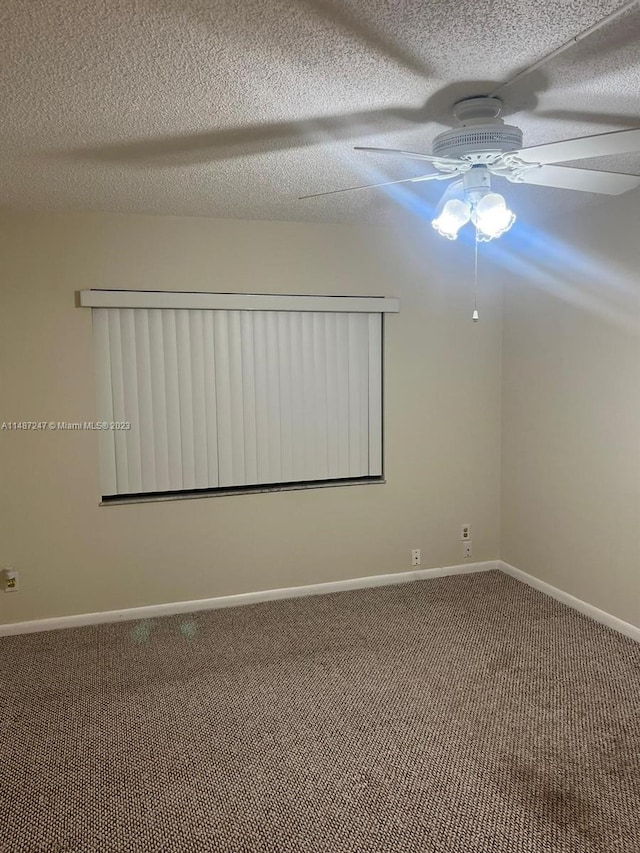 carpeted empty room featuring ceiling fan and a textured ceiling