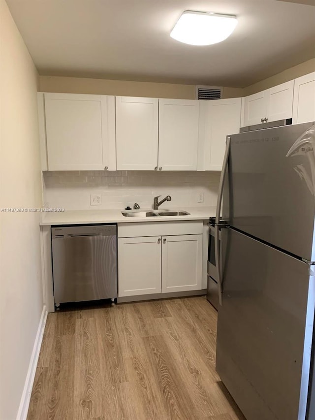 kitchen featuring white cabinetry, light hardwood / wood-style floors, appliances with stainless steel finishes, and sink