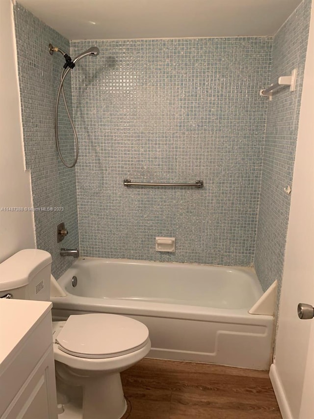 full bathroom featuring tiled shower / bath combo, toilet, vanity, and hardwood / wood-style flooring