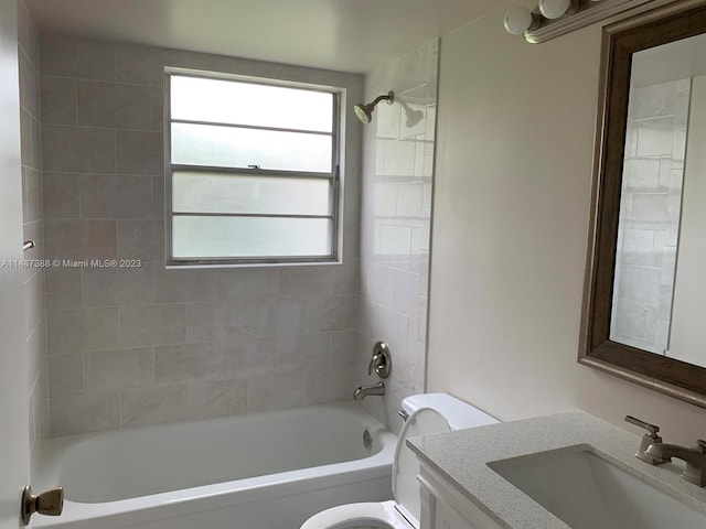 full bathroom featuring tiled shower / bath, toilet, and vanity