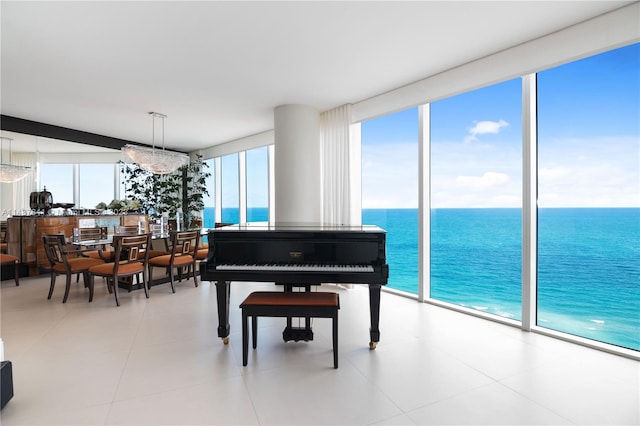 miscellaneous room with a water view, a wall of windows, and light tile floors