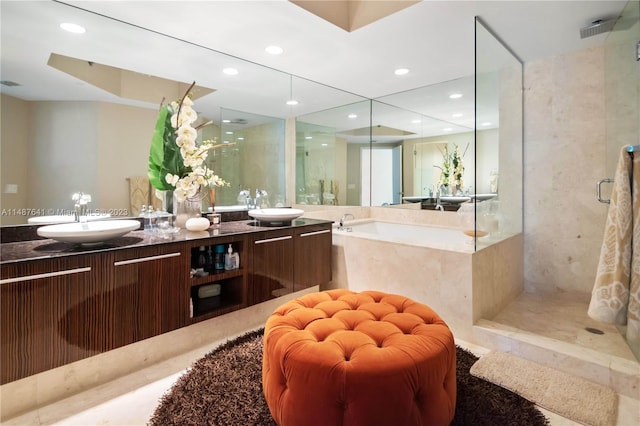 bathroom with double sink vanity and separate shower and tub