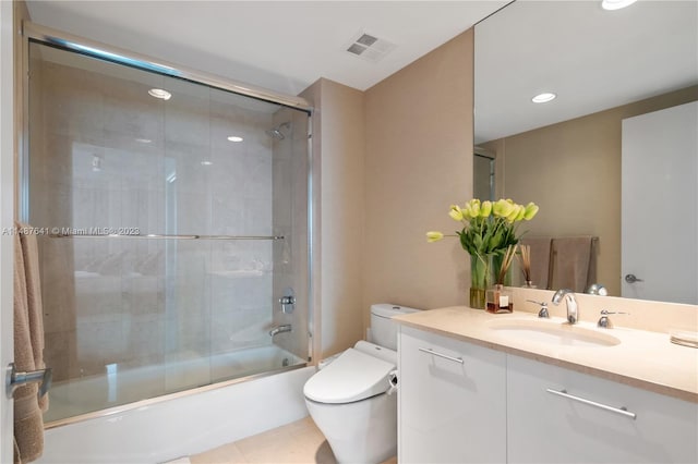 full bathroom featuring vanity, tile floors, bath / shower combo with glass door, and toilet