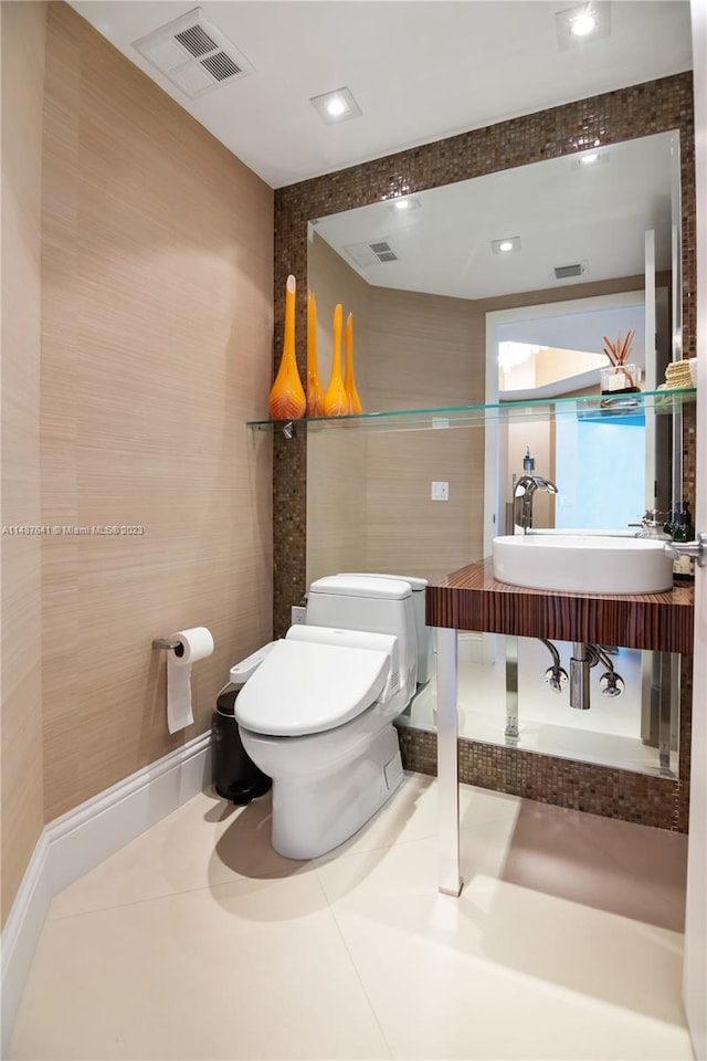 bathroom featuring sink, tile floors, toilet, and tile walls