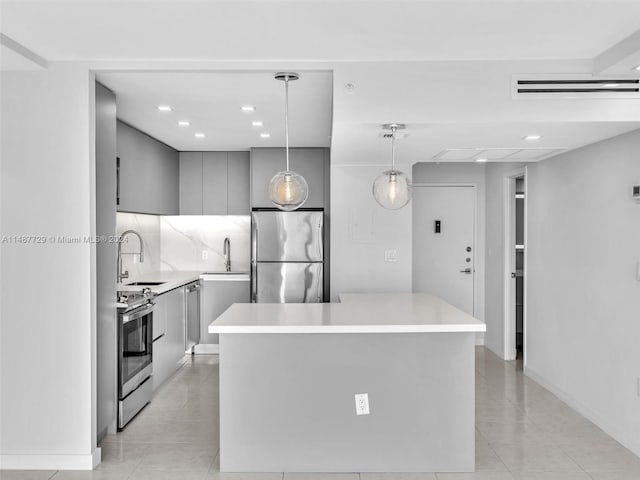 kitchen with gray cabinetry, stainless steel appliances, decorative light fixtures, and light tile flooring