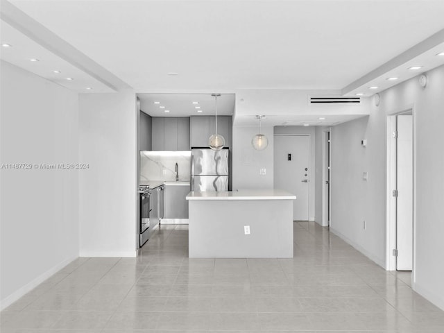 kitchen with appliances with stainless steel finishes, gray cabinets, hanging light fixtures, a center island, and light tile floors