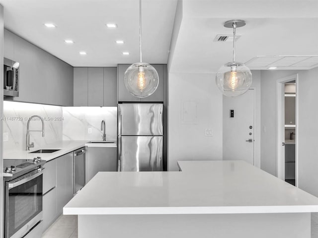 kitchen with pendant lighting, gray cabinets, stainless steel appliances, and sink