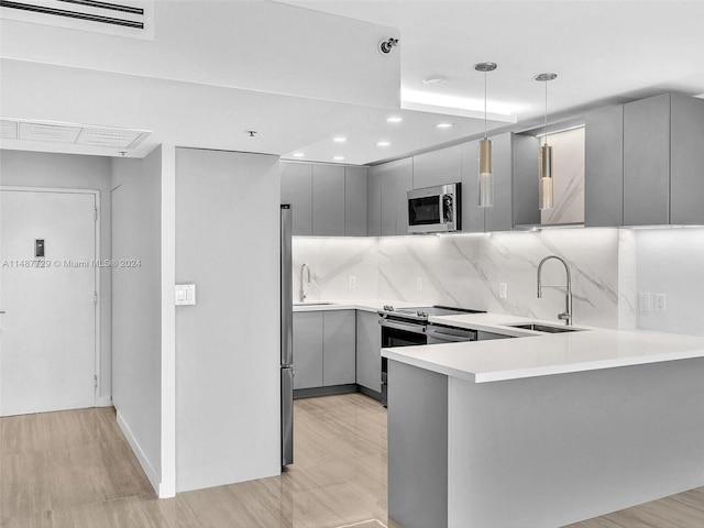 kitchen with tasteful backsplash, gray cabinets, sink, and range