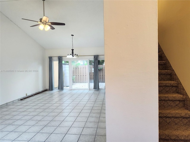 interior space featuring ceiling fan with notable chandelier, light tile patterned floors, and lofted ceiling